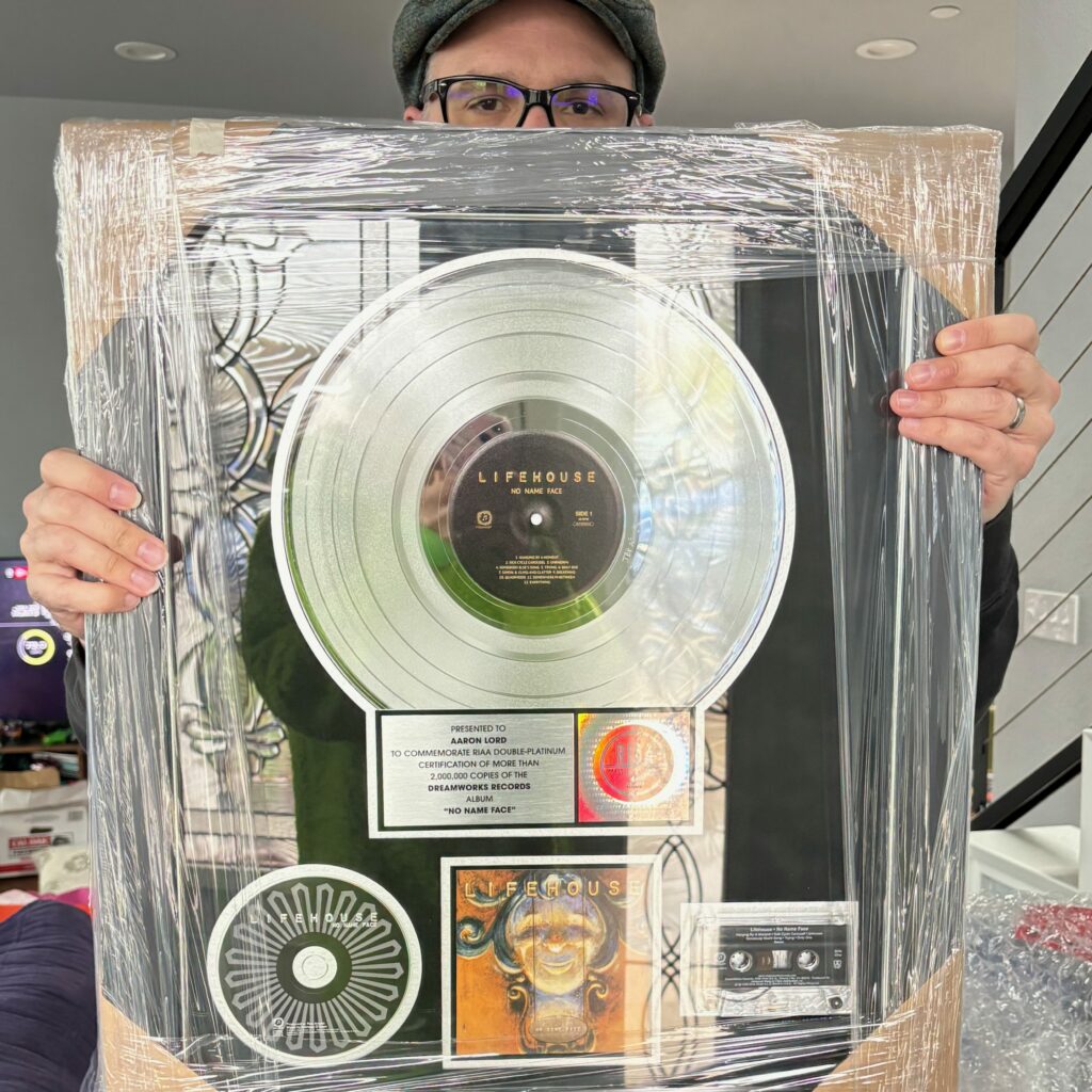 A picture of me holding a just-out-of-the-box double-platinum record award for the Lifehouse album "No Name Face."